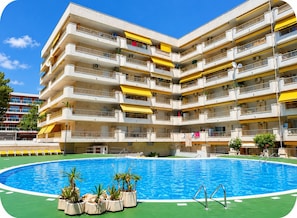 A multi-story building with a swimming pool in the foreground. - Yamila (Salou)