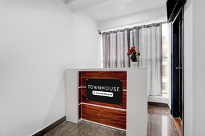 Zona de recepción con un cartel que indica 'TOWNHOUSE Company Serviced'.