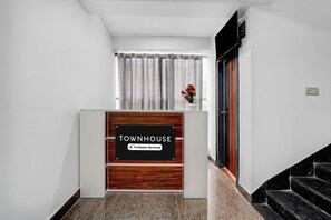 A reception desk with a sign indicating it is a company-serviced townhouse. - Townhouse Whitefield Railway Station (Bangalore)