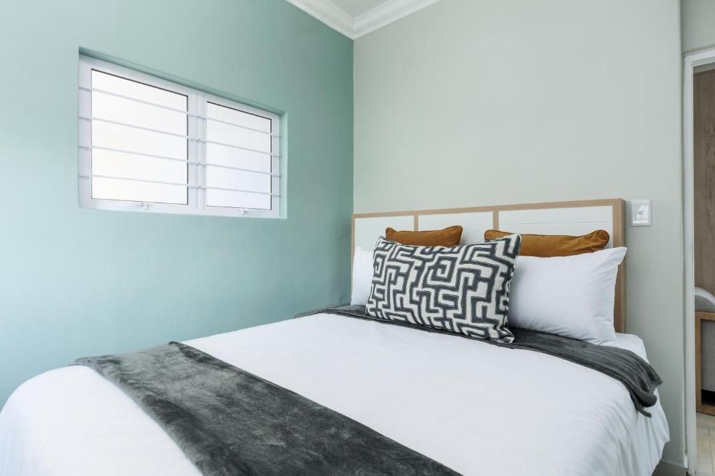 A bedroom with a bed, a window, and a door.