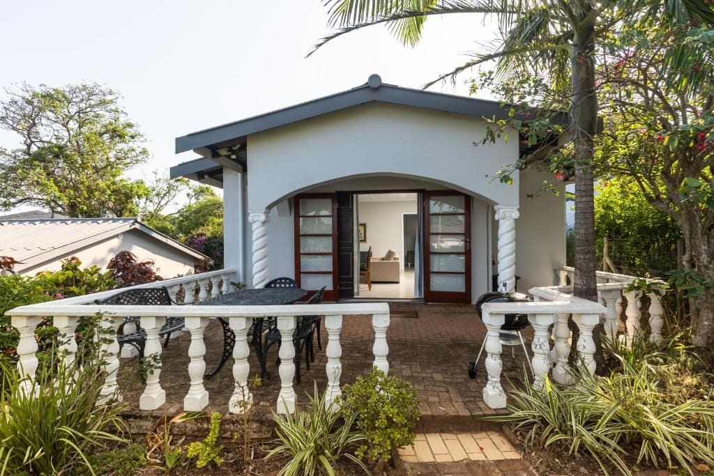 Une maison dotée d’un porche abrité, d’un coin repas et offrant une vue sur l’intérieur.