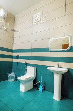 A bathroom with a toilet, sink, and a mirror on the wall. - Adam palace (Varkala)