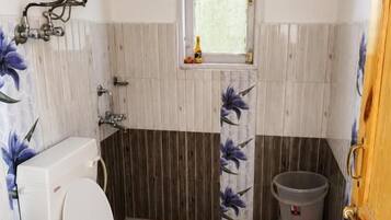 Une salle de bain avec des toilettes, un lavabo et une fenêtre.
