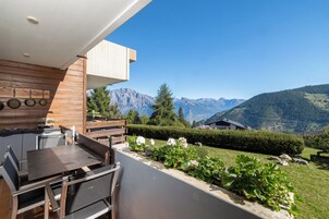 Una cocina moderna al aire libre con comedor y vistas a un paisaje montañoso.