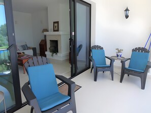 A modern living room with a fireplace, a dining area, and a seating arrangement with chairs and a table. - Apartment 'Residencia La Fuente' with Shared Pool, Wi-Fi and Air Conditioning (Mijas)