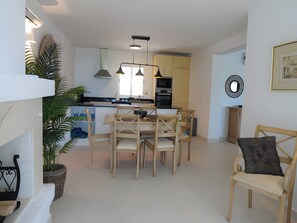 A modern kitchen with a dining area, featuring a central island, pendant lighting, and a view into the living space. - Apartment 'Residencia La Fuente' with Shared Pool, Wi-Fi and Air Conditioning (Mijas)