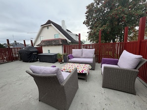 A patio with wicker furniture, a barbecue grill, and a potted plant. - Family Friendly House by Laugardalur Park & Pool, 2.5. km from Downtown (Reykjavík)