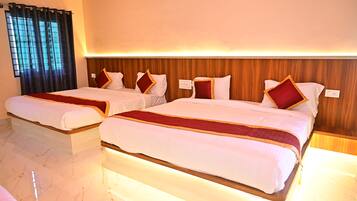 A hotel room with two beds, a wooden headboard, and a window with curtains.