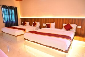 Una habitación de hotel con dos camas, un cabecero de madera y un ventanal con cortinas.