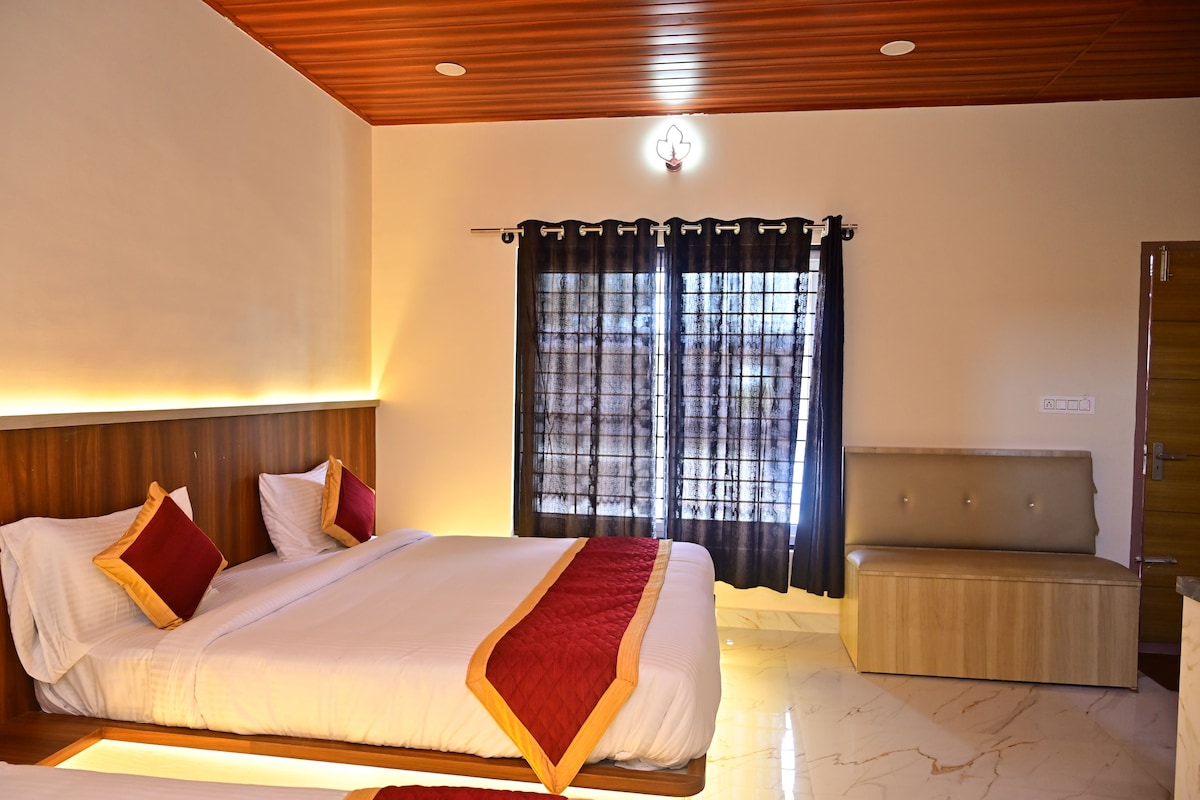 Quarto de hotel com cama, mesa de cabeceira e vista exterior através de uma janela com cortinas.