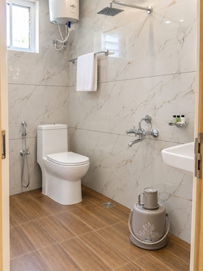 Une salle de bain moderne équipée de toilettes, d’une douche et d’un lavabo.