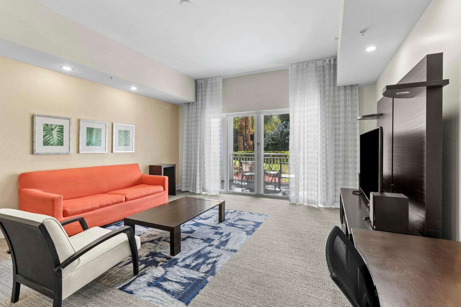 A modern living room with a sofa, coffee table, and TV stand.