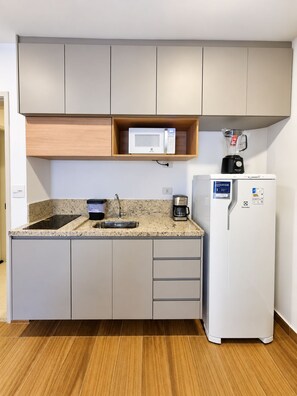 A compact kitchen with a microwave, coffee maker, and a refrigerator. - New Listing (São Paulo)