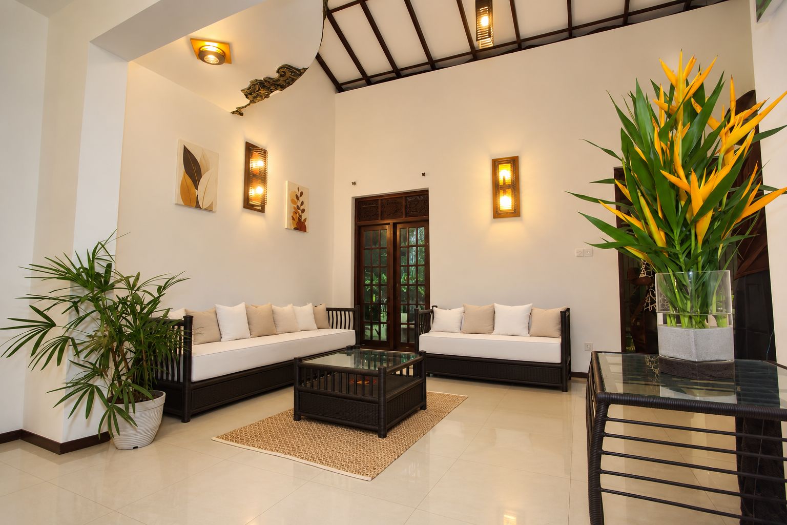 A modern living room with a sofa set, a coffee table, and decorative plants.