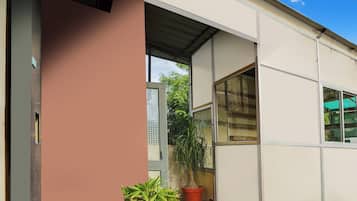 A building entrance with a door, windows, and a potted plant.