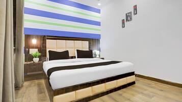 A modern bedroom with a large bed, a nightstand, a bedside table, and a wall-mounted light fixture.