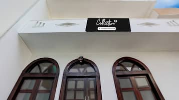 A building with a sign that reads 'Collection Company-Serviced' above three arched windows.