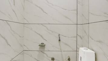 A bathroom with a toilet, a shower, and a built-in water heater.