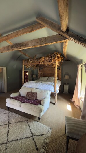 A bedroom with a four-poster bed, a sofa, and a chair. - Farmhouse Sleeps 13 With Hot Tub (Crewkerne)