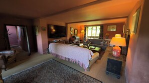 A cozy living room with a sofa, armchair, and a television. - Farmhouse Sleeps 13 With Hot Tub (Crewkerne)