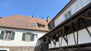 Un edificio tradicional con entramado de madera, tejado de tejas y muros de piedra.