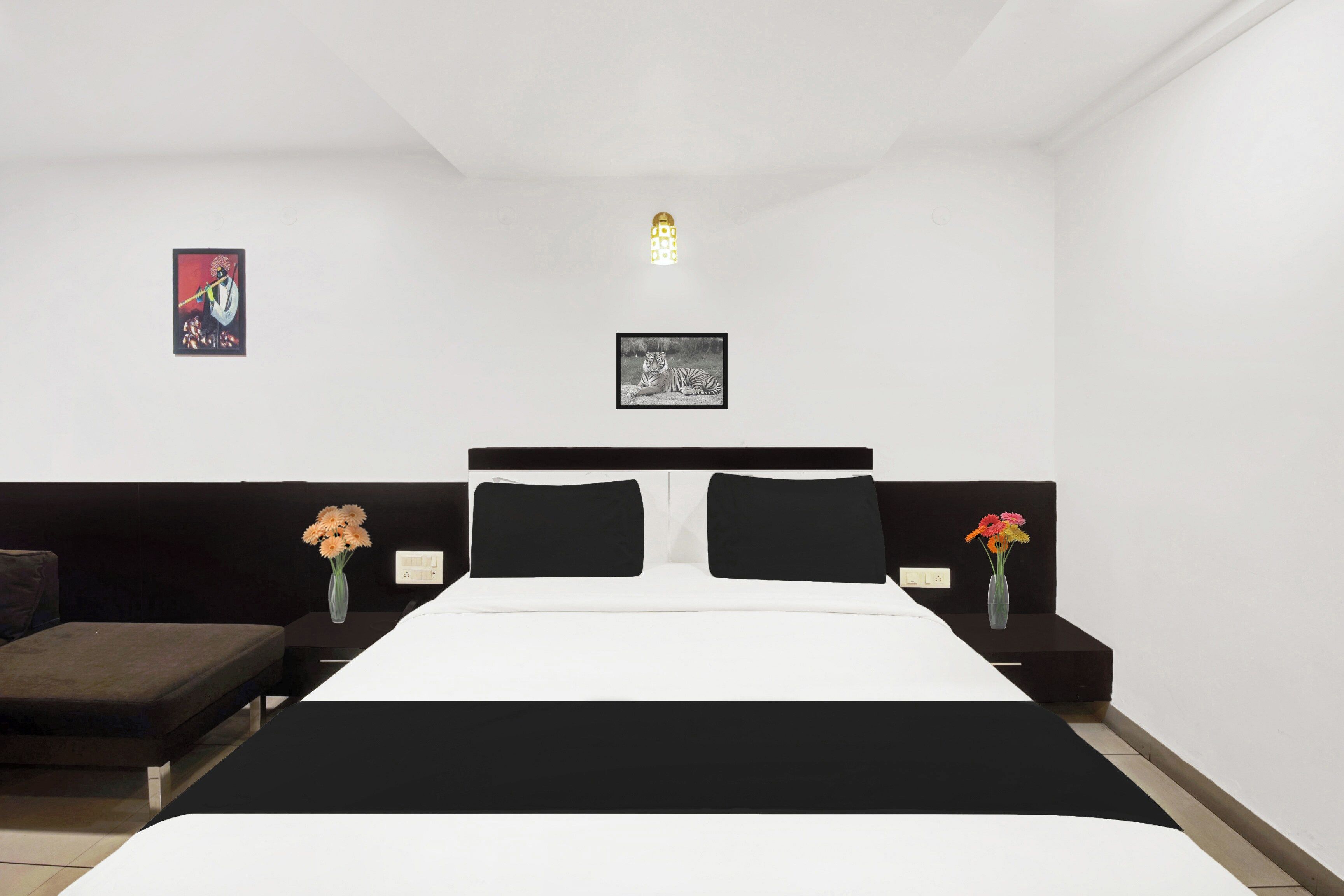 Un dormitorio con cama, dos mesitas de noche, cabecero y dos lámparas fijadas a la pared.