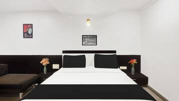 Un dormitorio con cama, dos mesitas de noche, cabecero y dos lámparas fijadas a la pared.