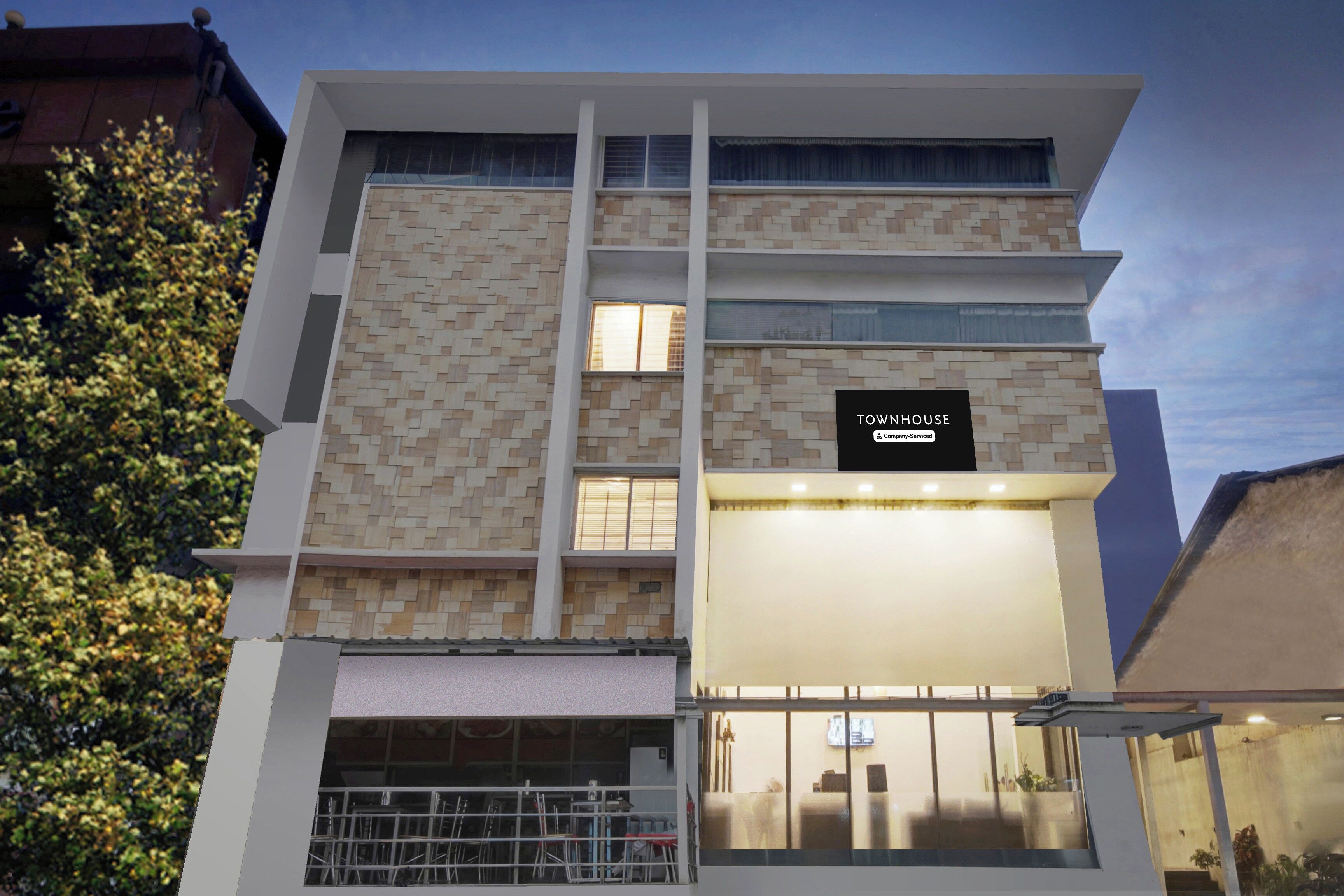 A multi-story building with a sign indicating it is a company-serviced townhouse.