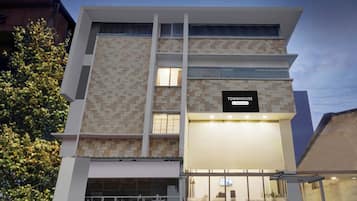 A multi-story building with a sign indicating it is a company-serviced townhouse.