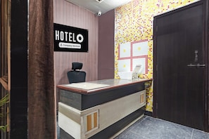 Una recepción de hotel con un letrero que indica que el servicio es proporcionado por la empresa.