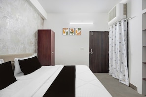 Un dormitorio con cama, armario, puerta y aire acondicionado instalado en la pared.
