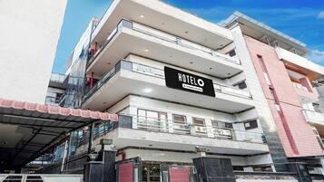 Un hotel de varios pisos con un llamativo letrero 'HOTEL', barandillas de vidrio y un diseño arquitectónico moderno.