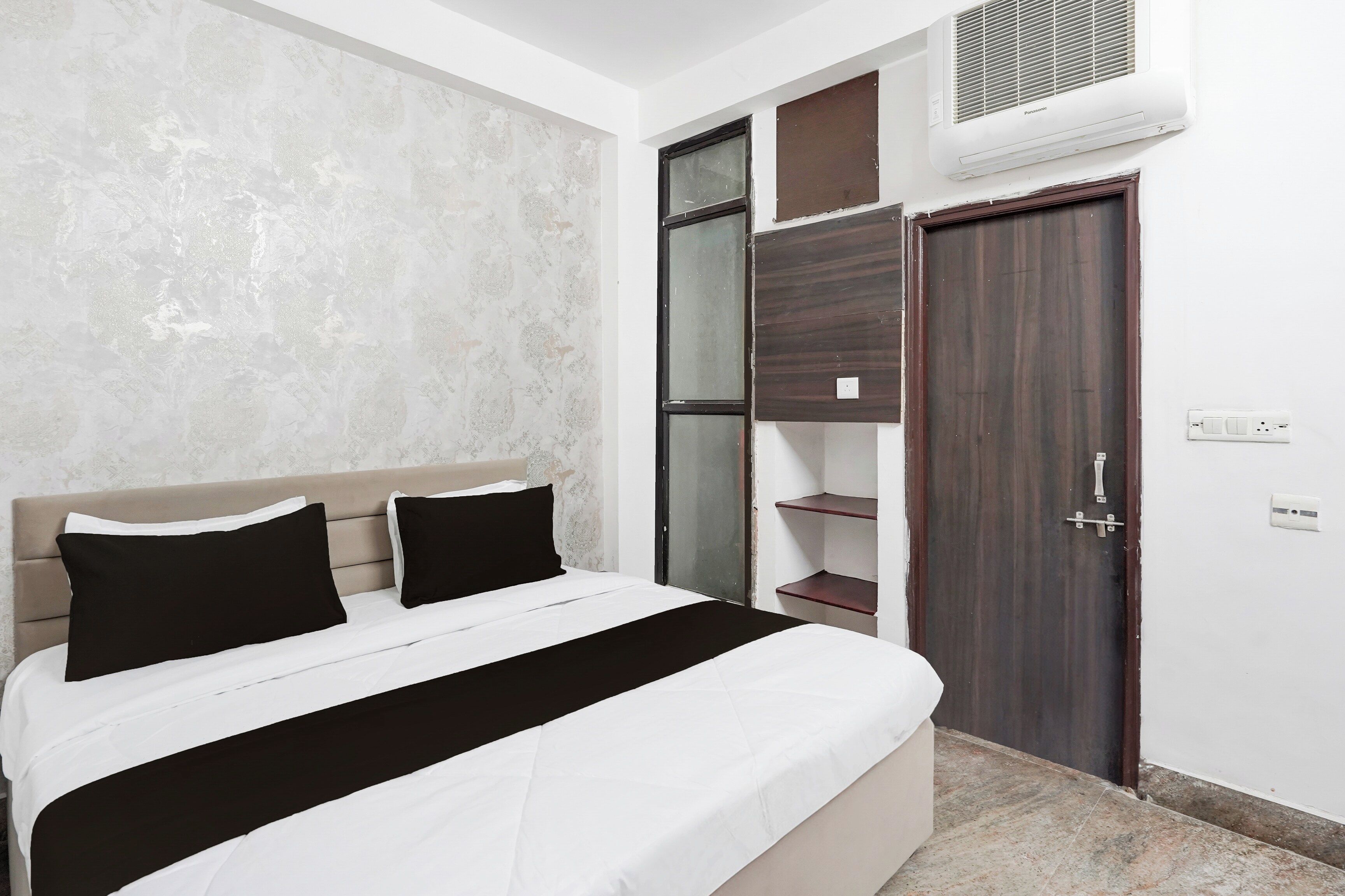 Un dormitorio con cama, armario y equipo de aire acondicionado.