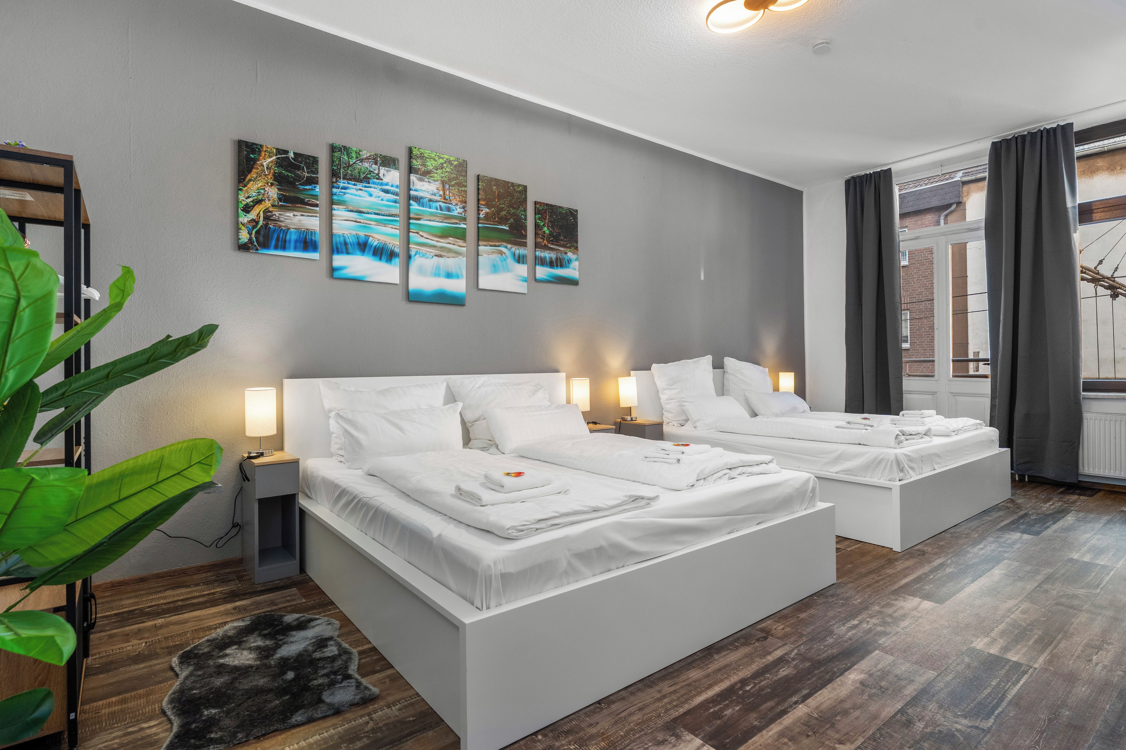 Une chambre d’hôtel moderne, dotée d’un grand lit, de tables de chevet et offrant une vue sur l’extérieur.