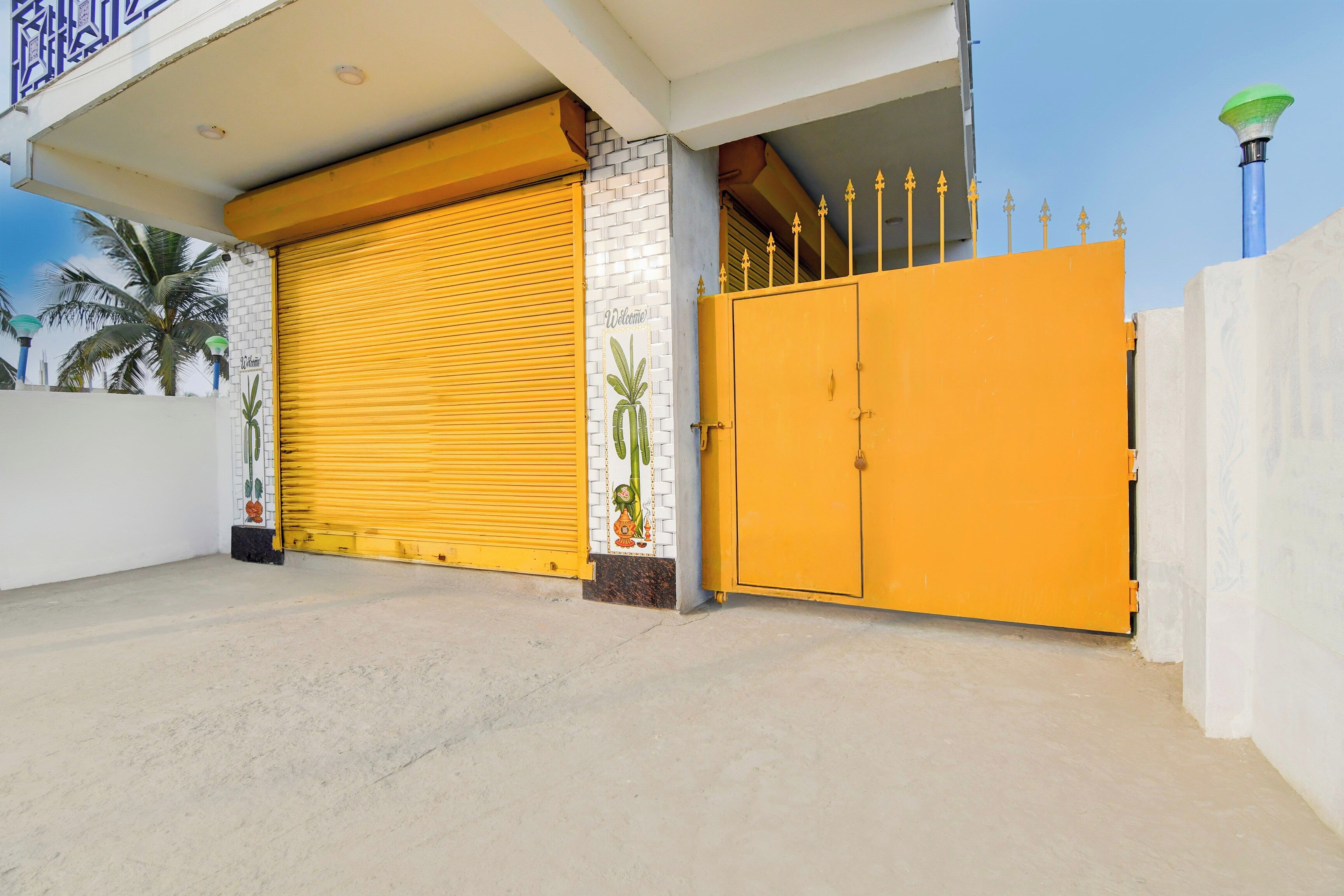 Un edificio con una puerta de garaje amarilla cerrada y un portón amarillo grande.