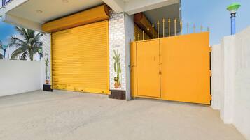 Un edificio con una puerta de garaje amarilla cerrada y un portón amarillo grande.