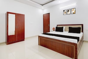 A bedroom with a wooden bed, a wardrobe, and a door.