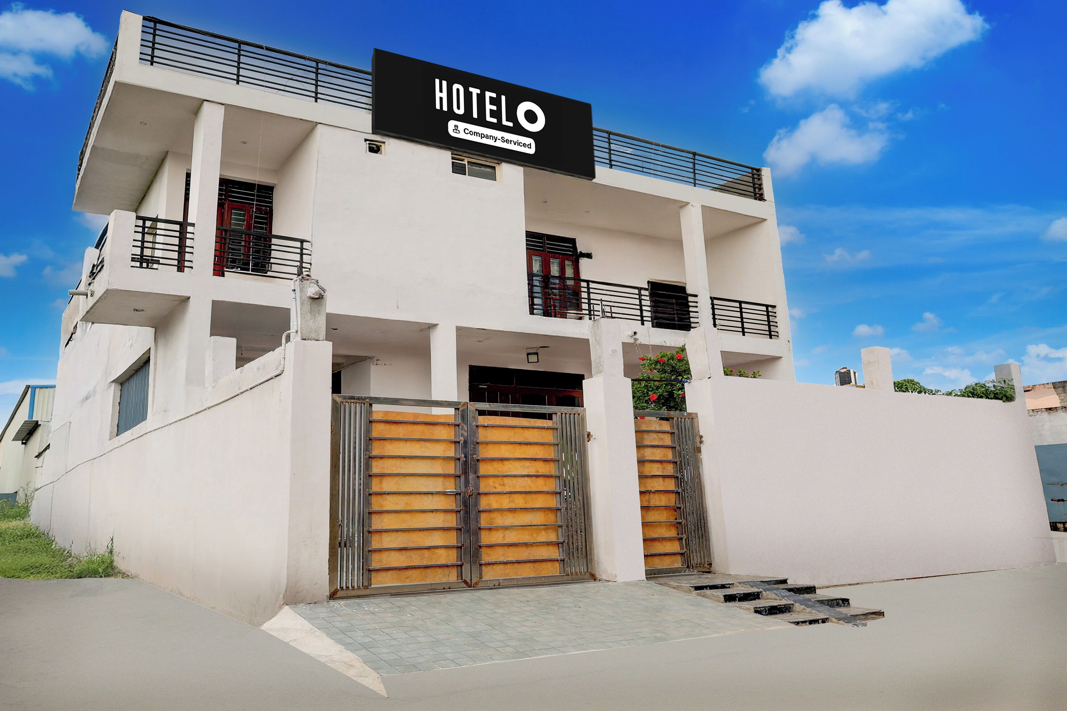 A modern hotel building with a sign indicating it is company-serviced.