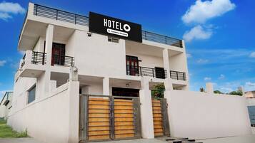 A modern hotel building with a sign indicating it is company-serviced.
