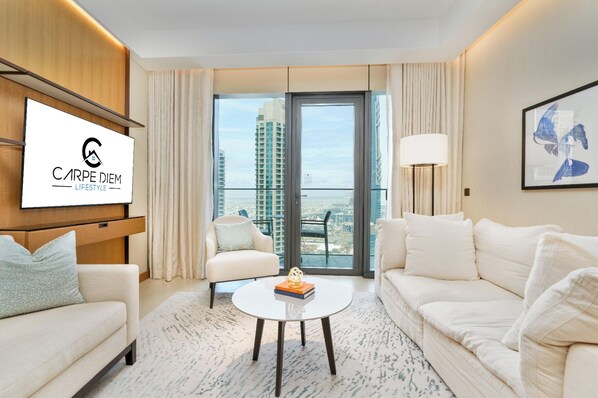 A modern hotel room with a large window, a flat-screen TV, a sofa, a chair, and a coffee table. - Bright apartment in brilliant Dubai with cool AC for your stay (Dubai)