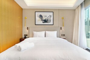 A hotel room with a large bed, two bedside tables, a wall-mounted artwork, and a window with curtains. - Bright apartment in brilliant Dubai with cool AC for your stay (Dubai)