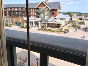 A view of a hotel courtyard with buildings, outdoor seating, and a paved area. - Mountain Retreat in the Village with Hot Tubs (Snowshoe)