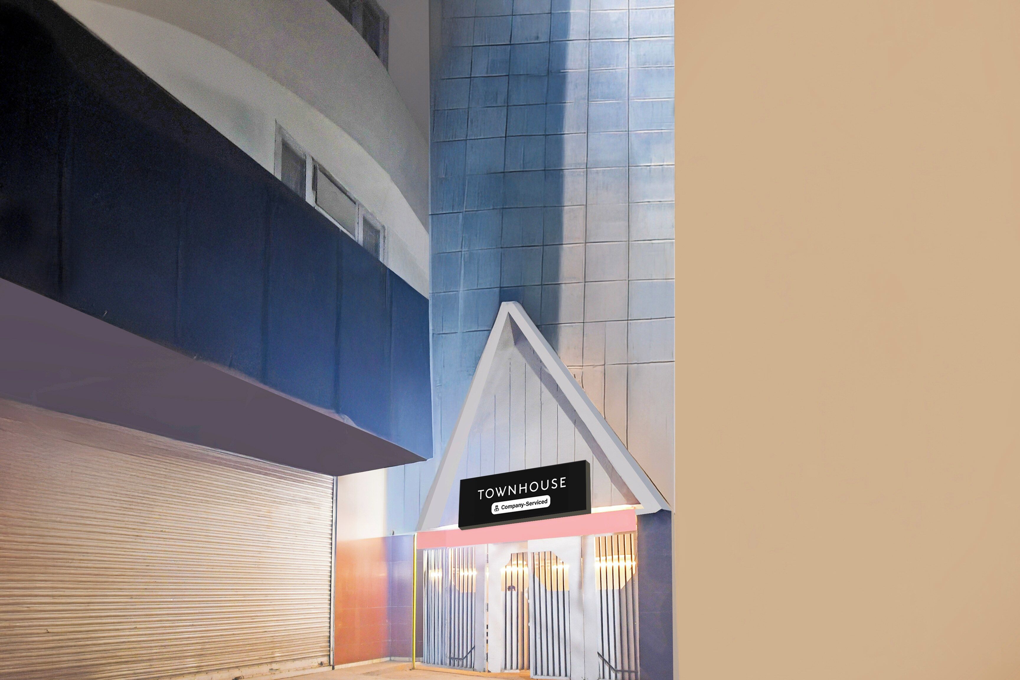 Interior de un hotel con una puerta persiana cerrada, un letrero que indica servicio de empresa, y un diseño moderno con paredes azules y blancas.