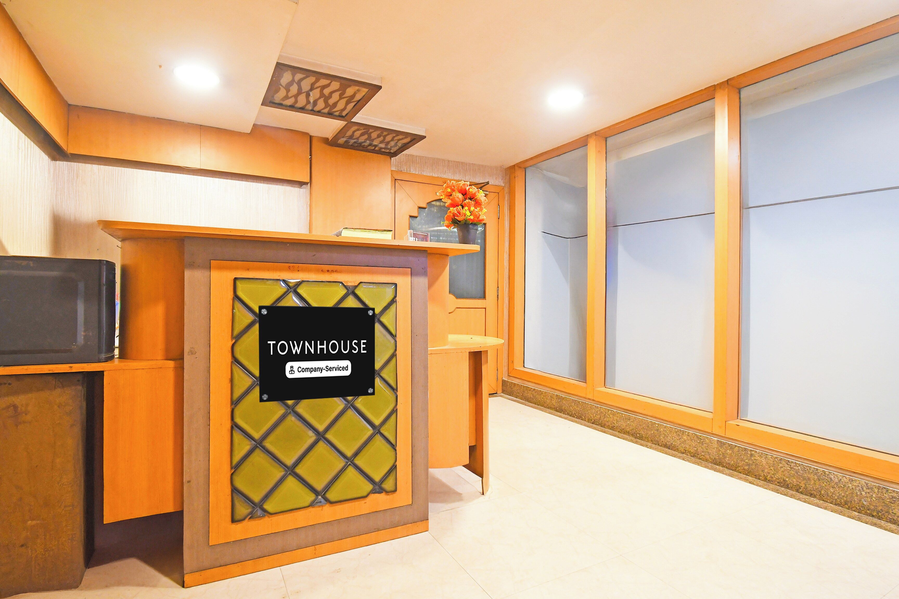 A reception desk with a sign reading 'TOWNHOUSE Company-Serviced.'