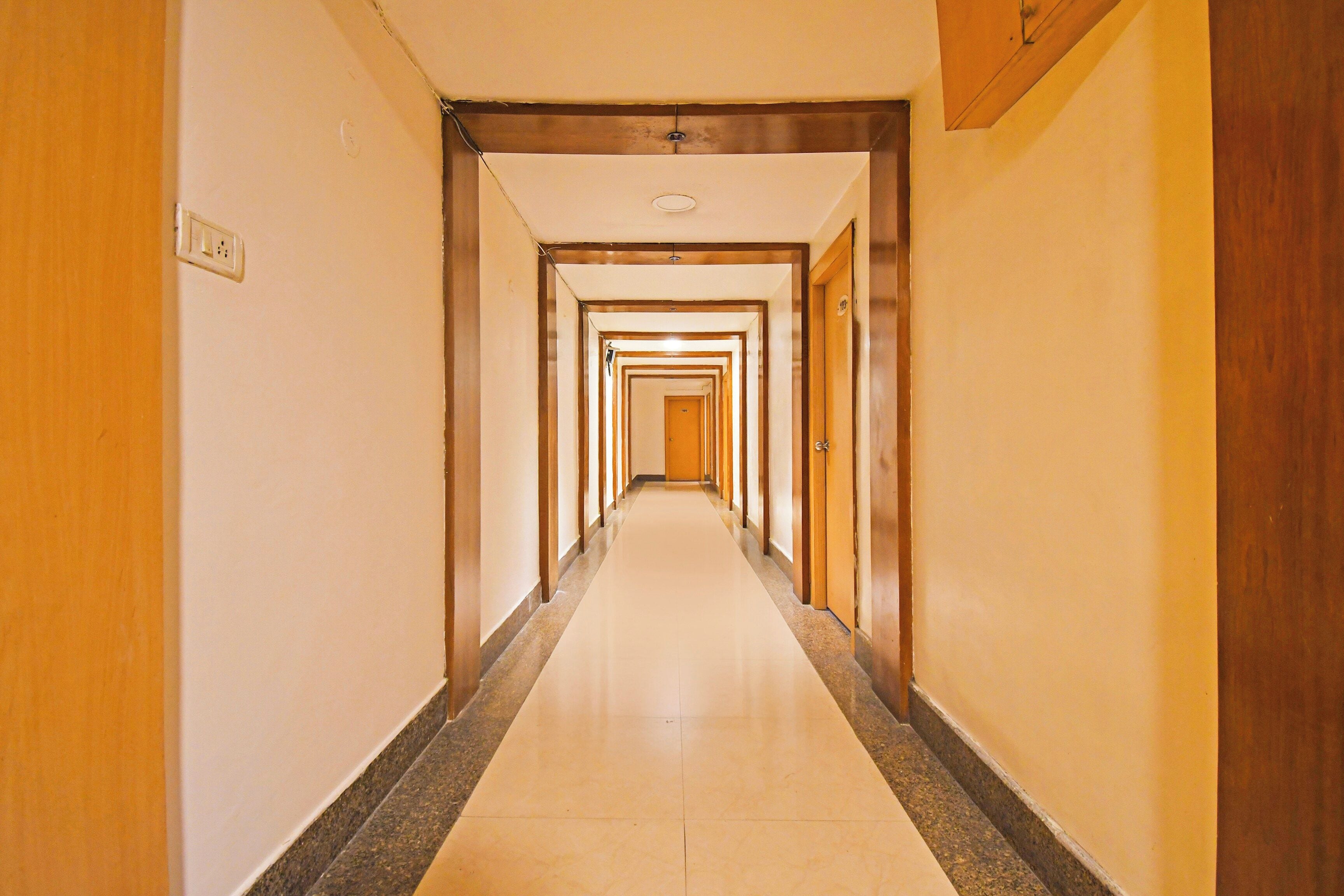 A hotel hallway with multiple doors and a tiled floor.