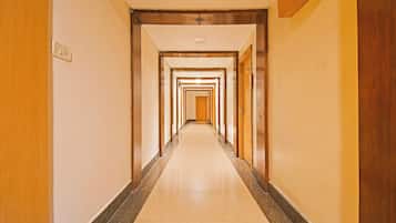 A hotel hallway with multiple doors and a tiled floor.