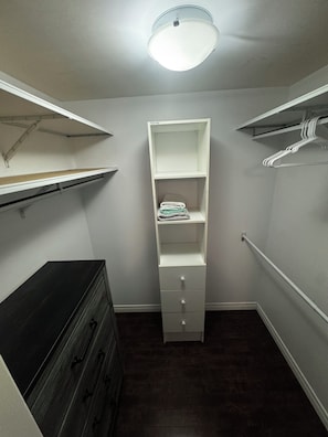 Una cabina armadio con un settimino, scaffali e un'asta appendiabiti.