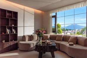 A modern living room with a sectional sofa, a coffee table, and a bookshelf.
