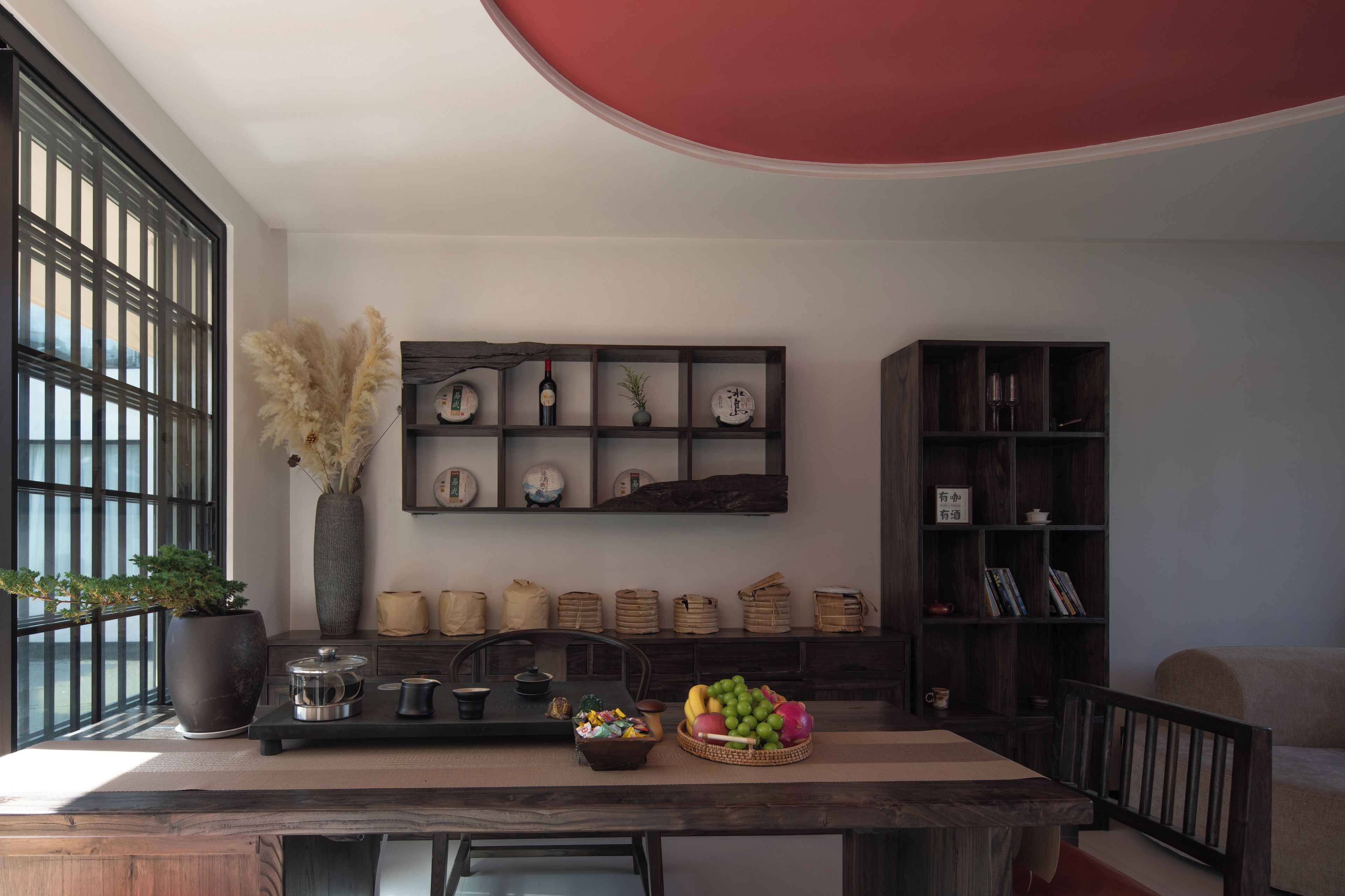 A modern kitchen with a dining table, a coffee machine, and a fruit basket.