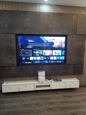 Televisor de pantalla plana montado en una pared con textura, con un mueble de madera debajo.